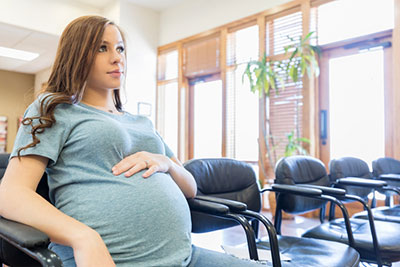 pregnant woman sitting in a resource center waiting for hep